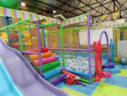 Indoor play area with colorful padded stairs, ball pit with white balls, and soft foam flooring sections