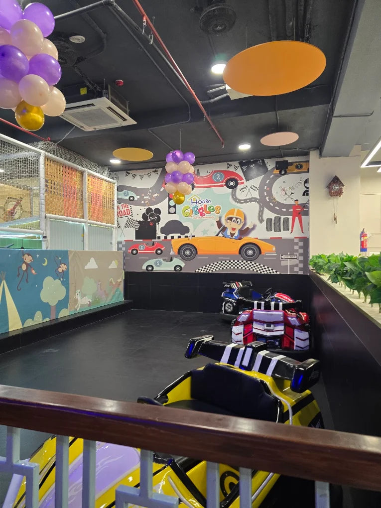 Children's indoor play area with bumper cars and colorful decorations.