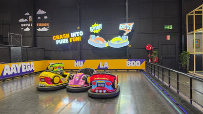 Bumper cars in an indoor amusement park with colorful decorations and playful signage.