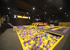 An indoor trampoline park with foam pits and colorful trampolines, likely for children and teens.
