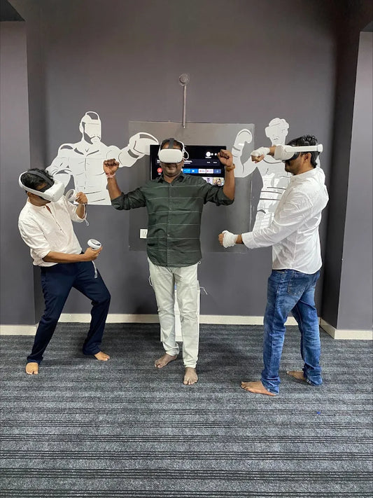 Three men in VR headsets play a boxing game in a room with boxing-themed wall art.