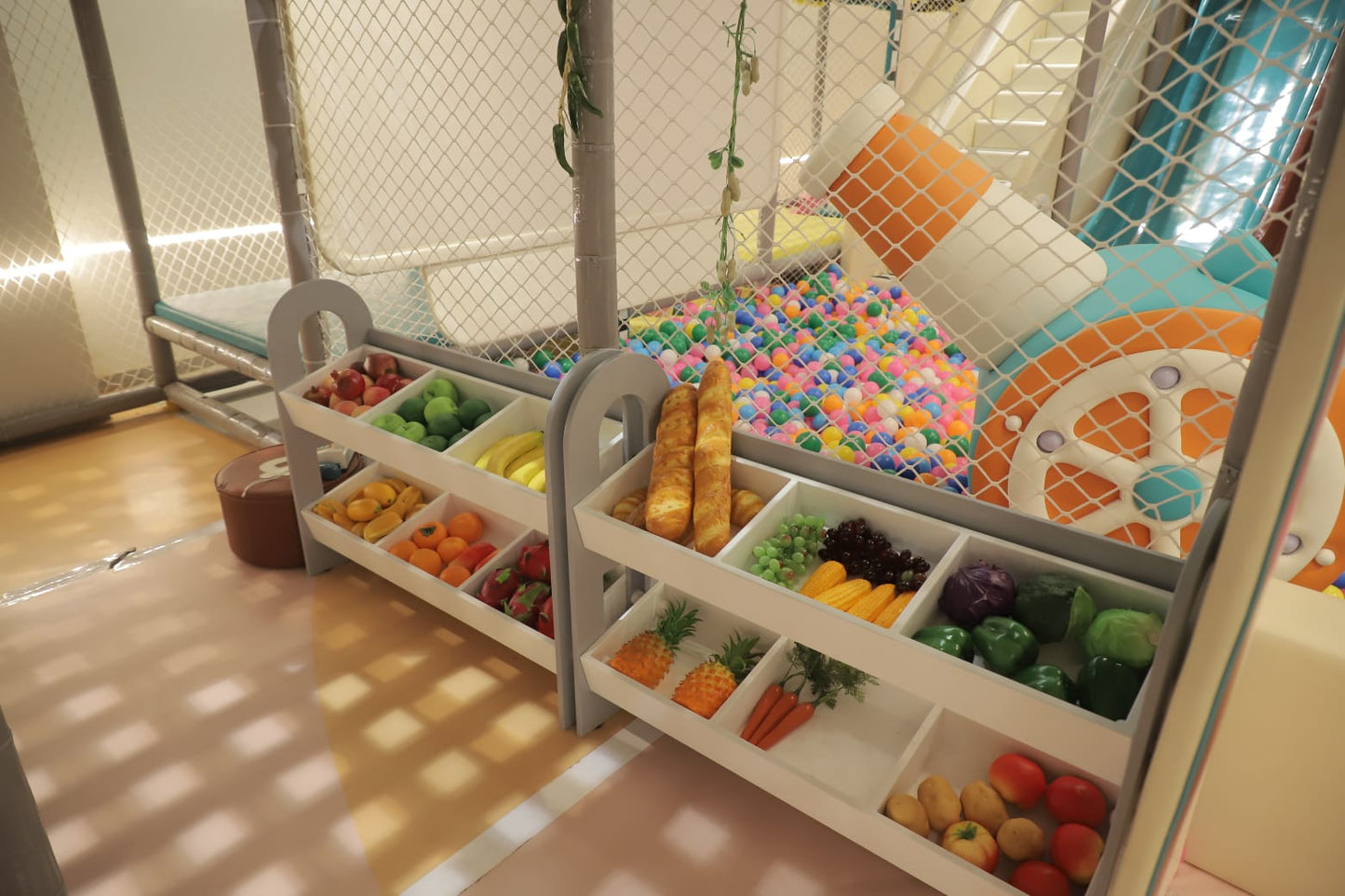 Play area with toy fruits, vegetables, and a colorful wheel.