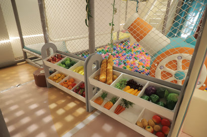 Play area with toy fruits, vegetables, and a colorful wheel.