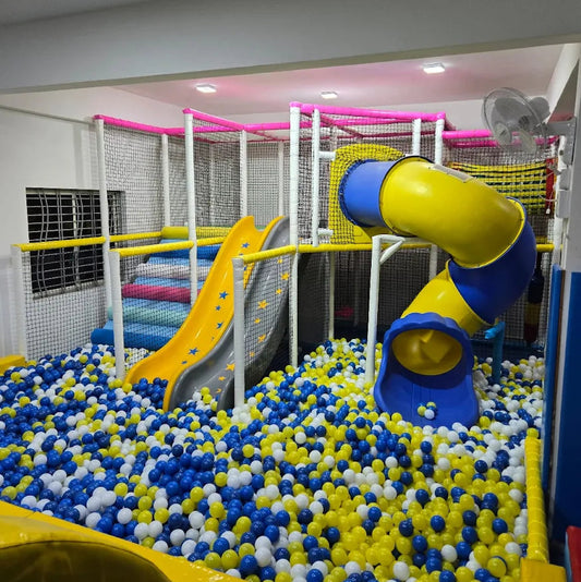 A colorful indoor playground with slides, a ball pit, and climbing structures for children.