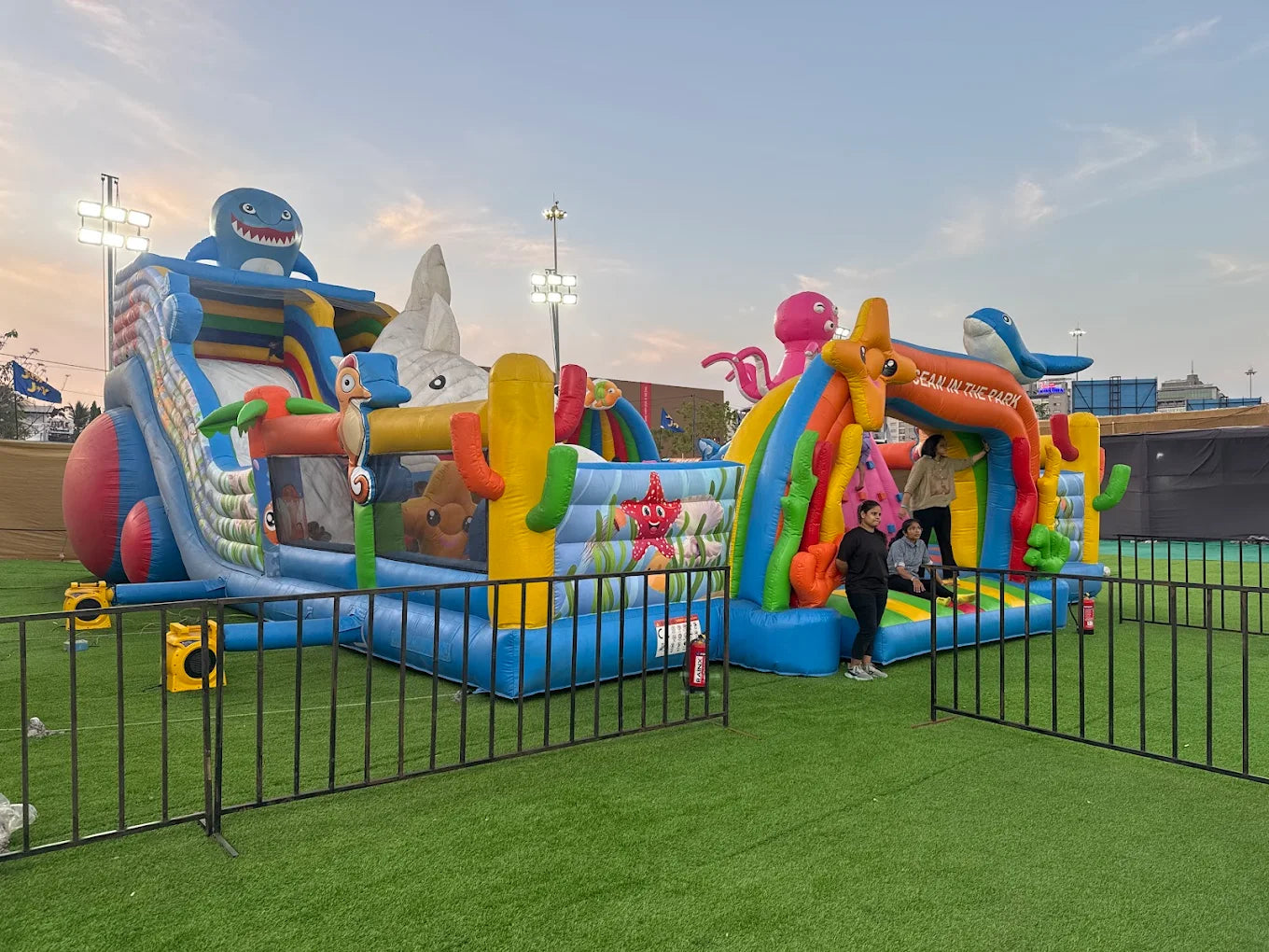 Children play on a colorful ocean-themed inflatable obstacle course.
