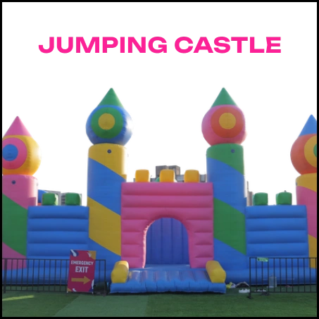A colorful inflatable jumping castle with turrets and an arched entrance, set up on a grassy field.