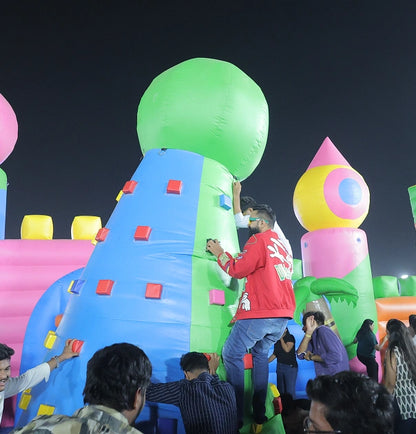 Young adults climb an inflatable obstacle course at night.