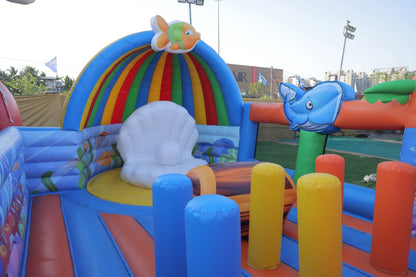 An inflatable ocean-themed bouncy castle with colorful arches, a giant pearl, and playful sea creatures.
