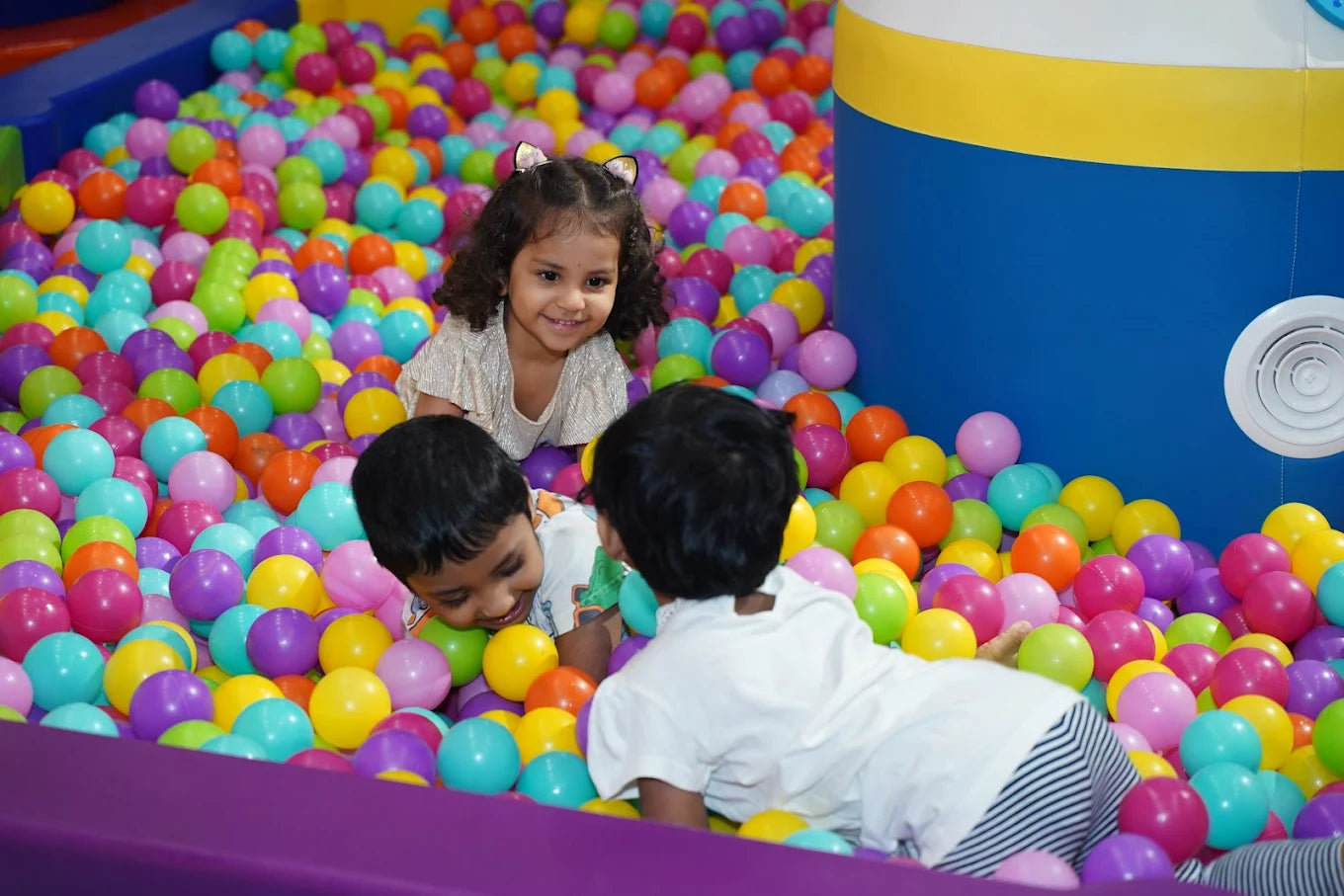 Children play in a ball pit filled with colorful balls.