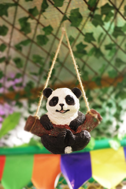 Adorable panda figure sitting on a wooden swing against leafy backdrop at indoor play area Sector 104 Hazipur