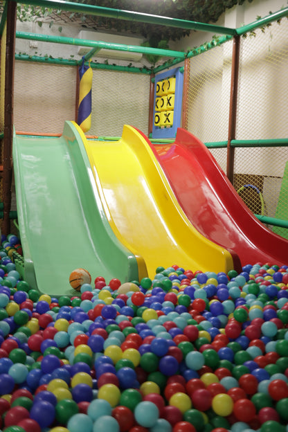 Three vibrant slides in green, yellow, and red leading into a colorful ball pit at Jumping Jollies Sector 104 Hazipur Noida