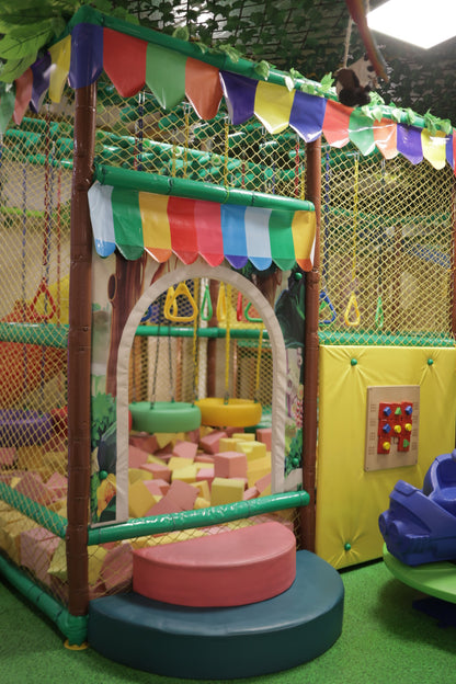Colorful playground structure with slides and climbing elements in an indoor setting.