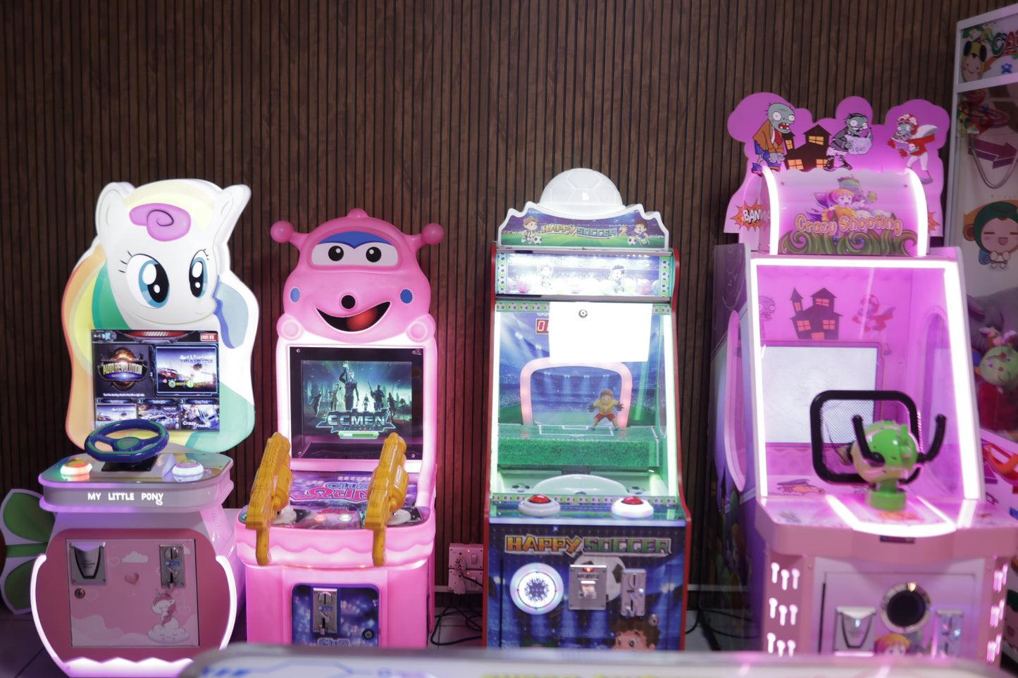 Four pastel-themed arcade game machines with vibrant LED lighting inside indoor play area at Sector 104 Hazipur Noida