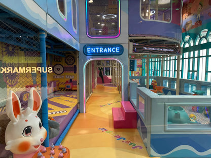 A colorful indoor playground with a bunny mascot and a neon "Entrance" sign.