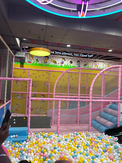 A colorful ball pit with a slide in a children's play area.
