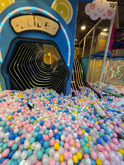A colorful ball pit filled with children's toys and a soft play structure.