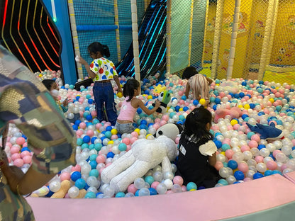 Children play in a ball pit with stuffed animals.