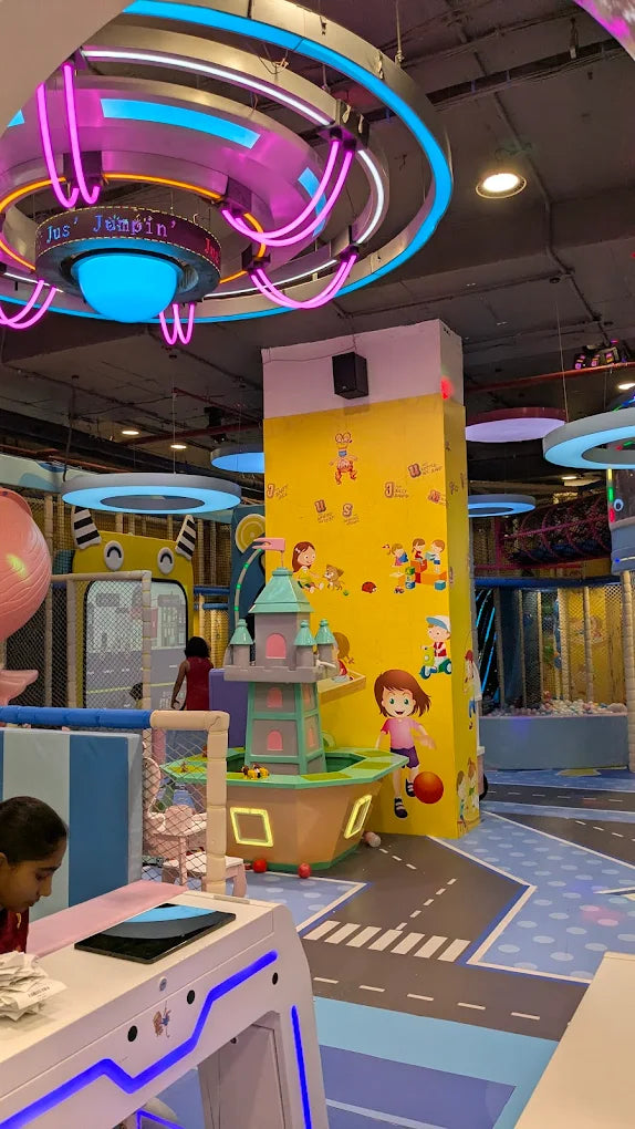 A vibrant indoor playground with colorful decorations and children playing.