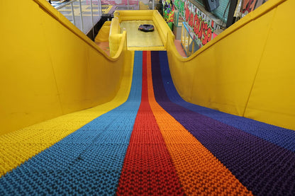 Colorful slide with a multicolored floor in an indoor playground.