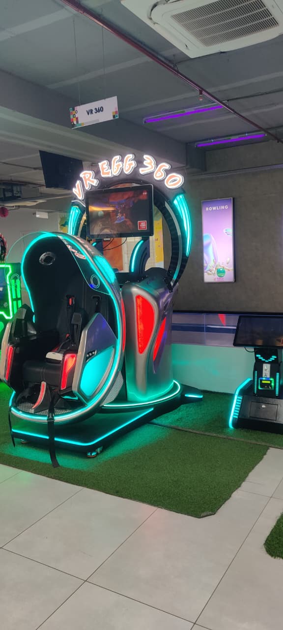 A futuristic VR egg 360 ride with neon lights and a screen displaying a game.