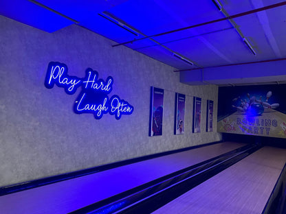 A bowling alley with neon signs and posters for laser tag and virtual reality.
