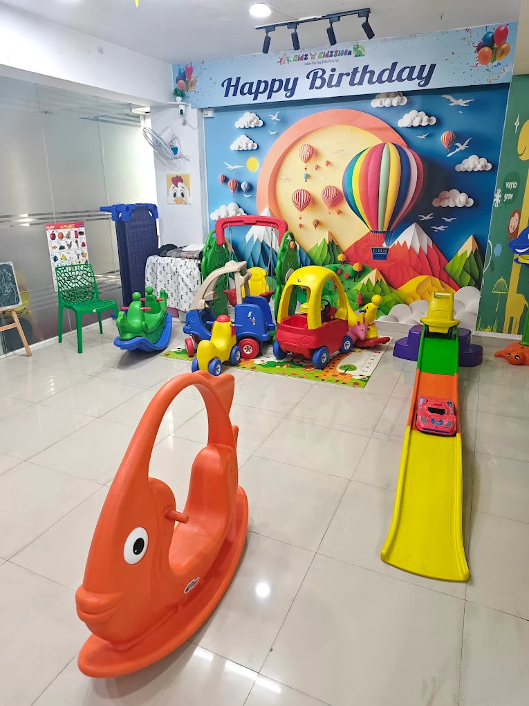 A brightly decorated room for young children, featuring a "Happy Birthday" banner, toys, and a rocking fish.