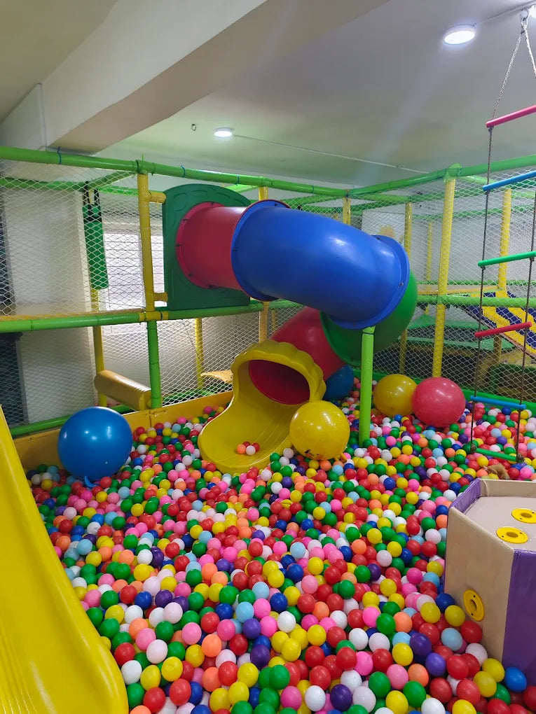 A colorful indoor playground with slides and a ball pit for children.