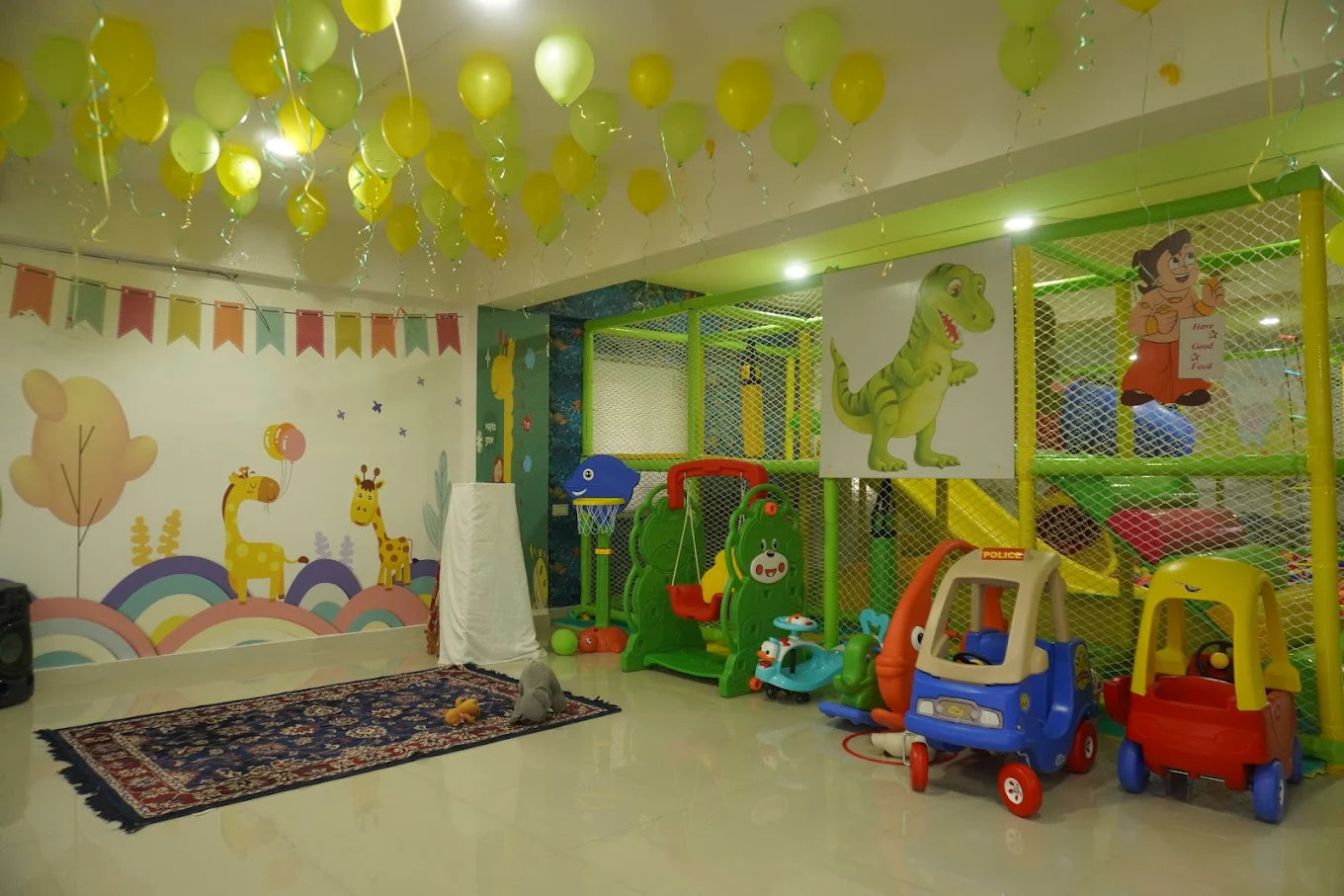 A brightly decorated indoor play area for young children, featuring a soft play structure, toys, and colorful wall art.