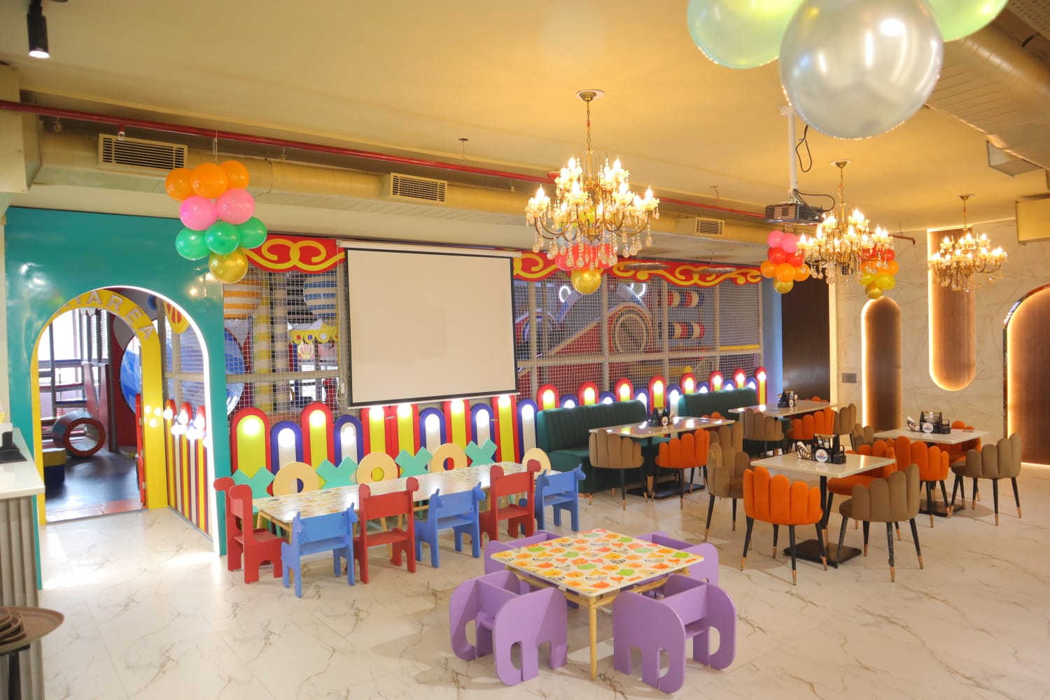 A colorful indoor playground with tables and chairs for children.