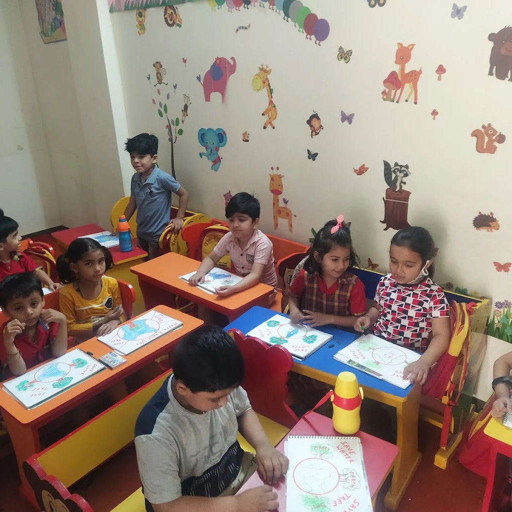Children sitting at desks in a classroom with colorful decorations on the walls.