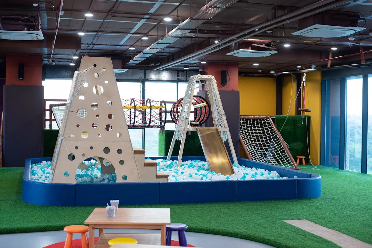 An indoor playground with a ball pit, slide, and climbing structures for children.