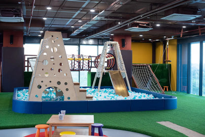 An indoor playground with a ball pit, slide, and climbing structures for children.