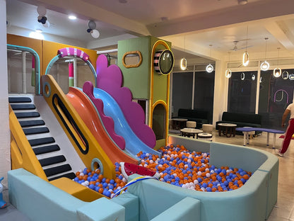 A colorful indoor playground with slides and a ball pit, designed for children.