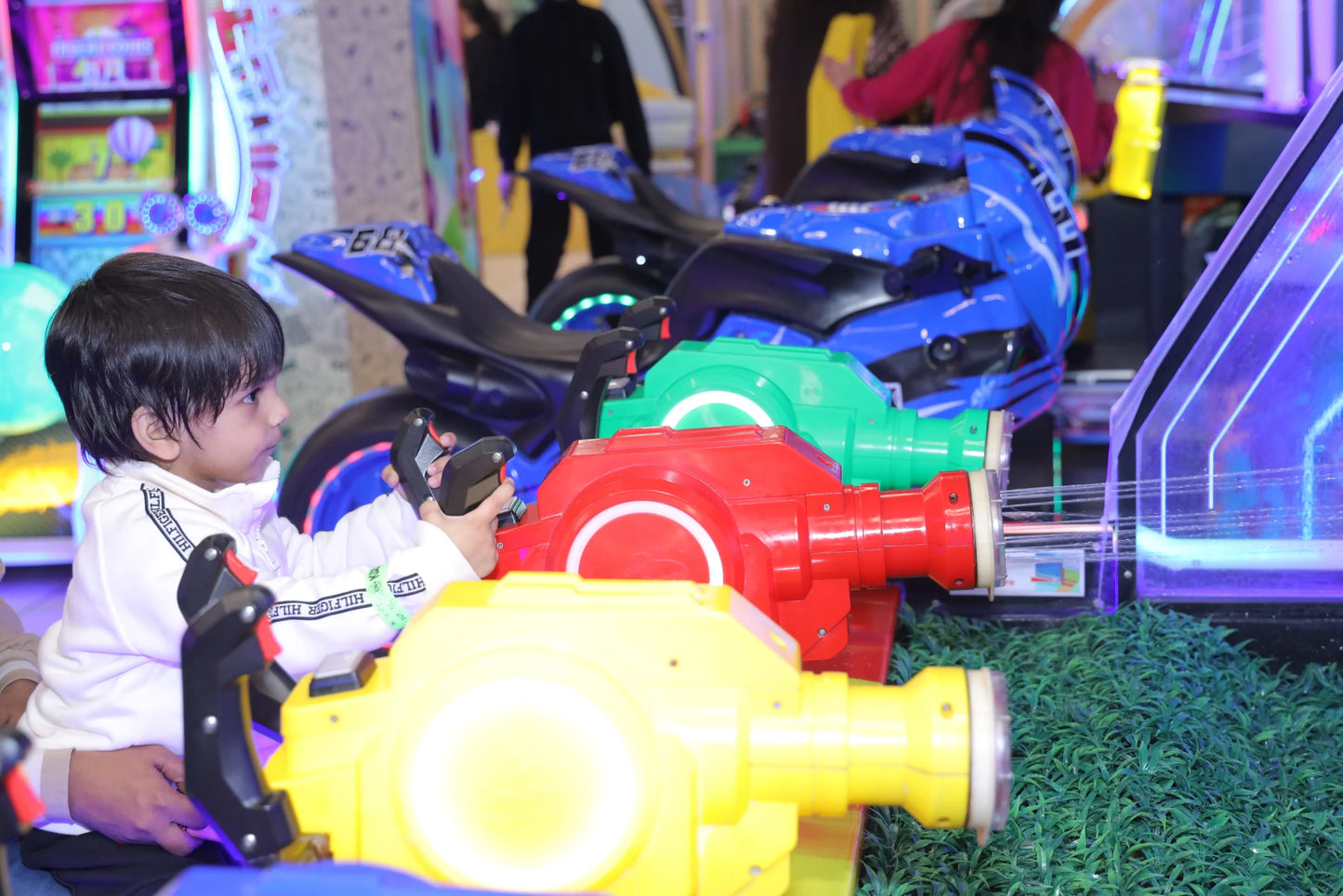 Child playing with toy cars in an indoor amusement area