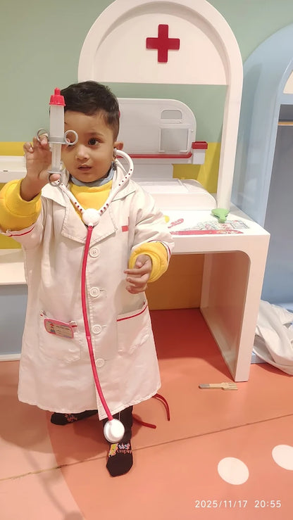 A young child dressed as a doctor holds a toy syringe and stethoscope in a play clinic.