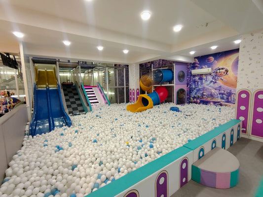 A ball pit with slides and climbing structures in a children's play area.