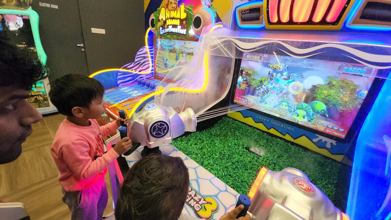 Children play a water-squirting arcade game at an amusement center.
