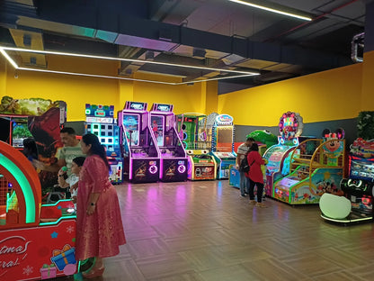 Family plays arcade games in a brightly lit entertainment center.