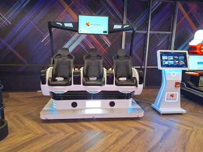 A VR simulator with three seats and a touch screen kiosk in an arcade.