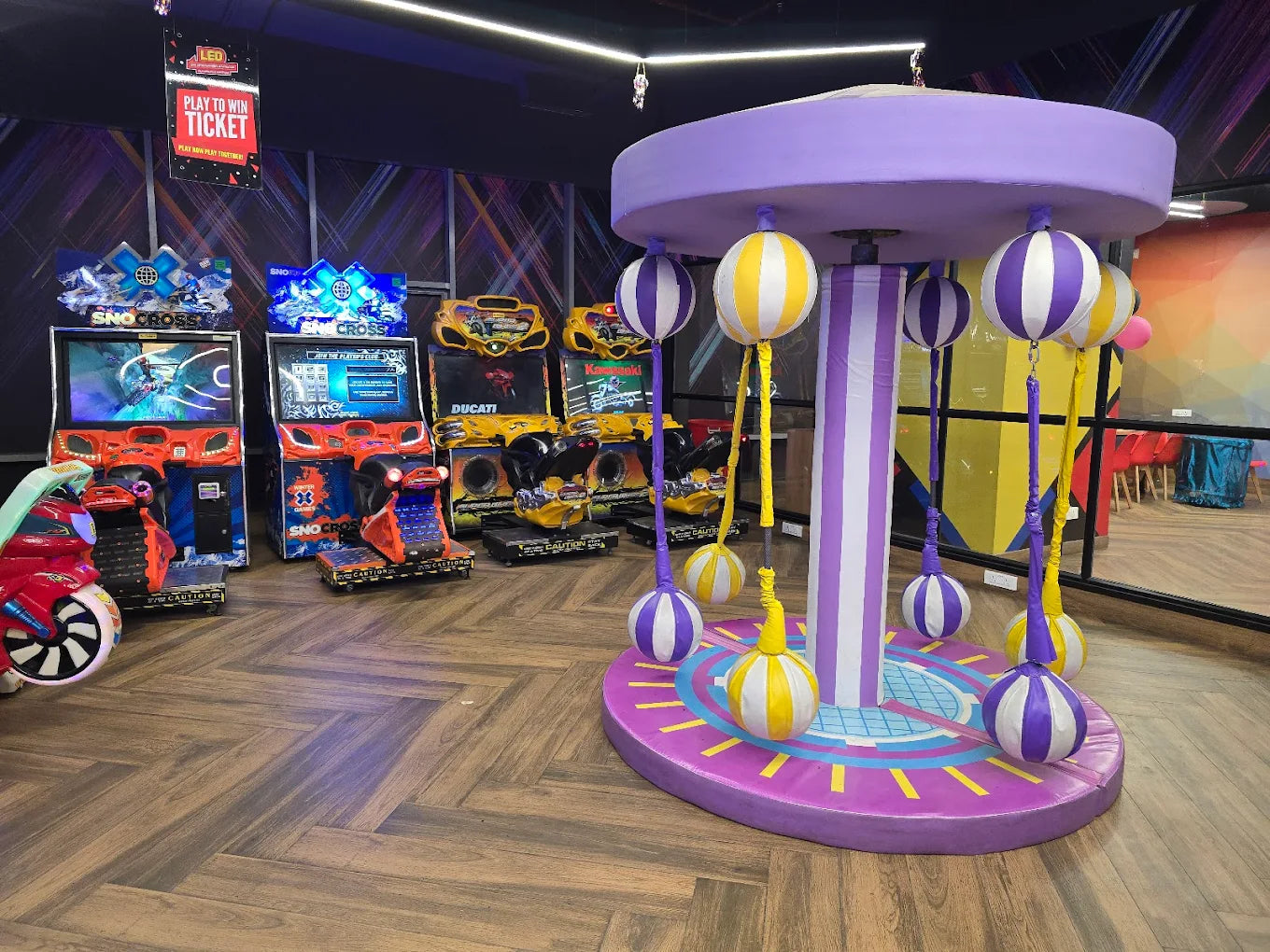 Arcade with racing games and a colorful carousel for children.