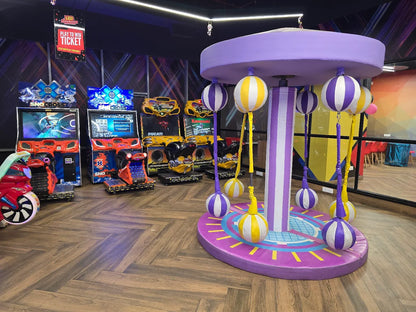 Arcade with racing games and a colorful carousel for children.