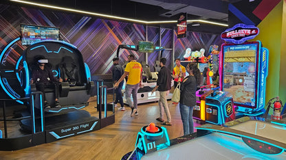Young adults enjoy VR and arcade games in a brightly lit entertainment center.