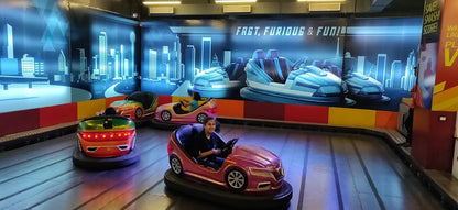 Children enjoy riding bumper cars in an arcade with a futuristic cityscape backdrop.