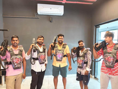Young men in a laser tag arena, wearing vests and holding phasers, ready to play.