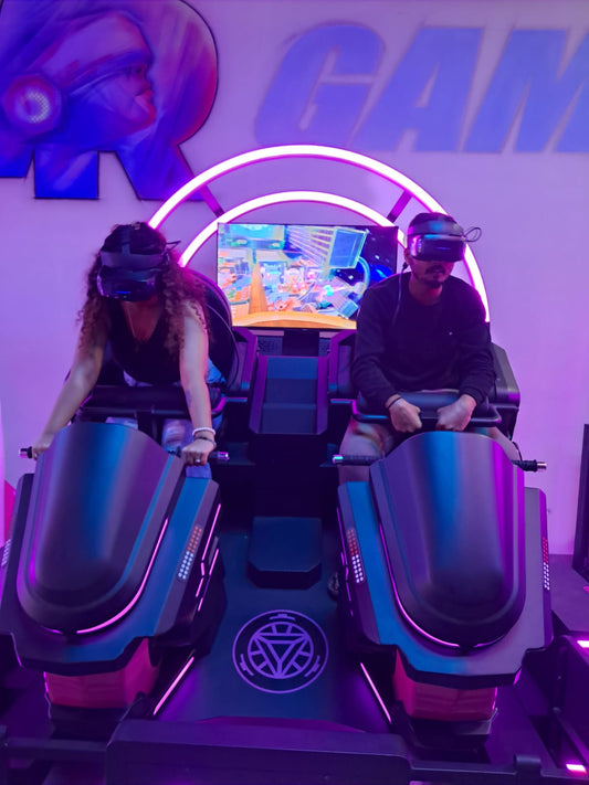 Two young adults experience a virtual reality game in a futuristic arcade.