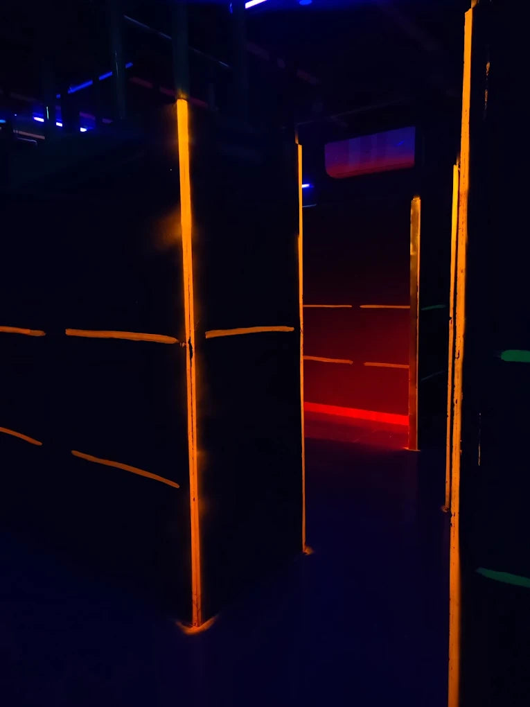 A dark laser tag arena with glowing orange and red lights.