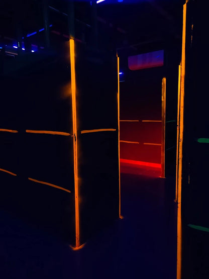 A dark laser tag arena with glowing orange and red lights.