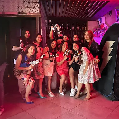 Group of women posing together in a room with neon lighting