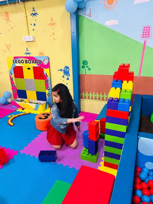 Child playing with colorful building blocks in a playroom.