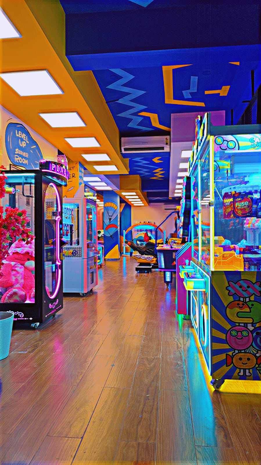 An arcade with colorful machines and neon lights, featuring games for children and adults.